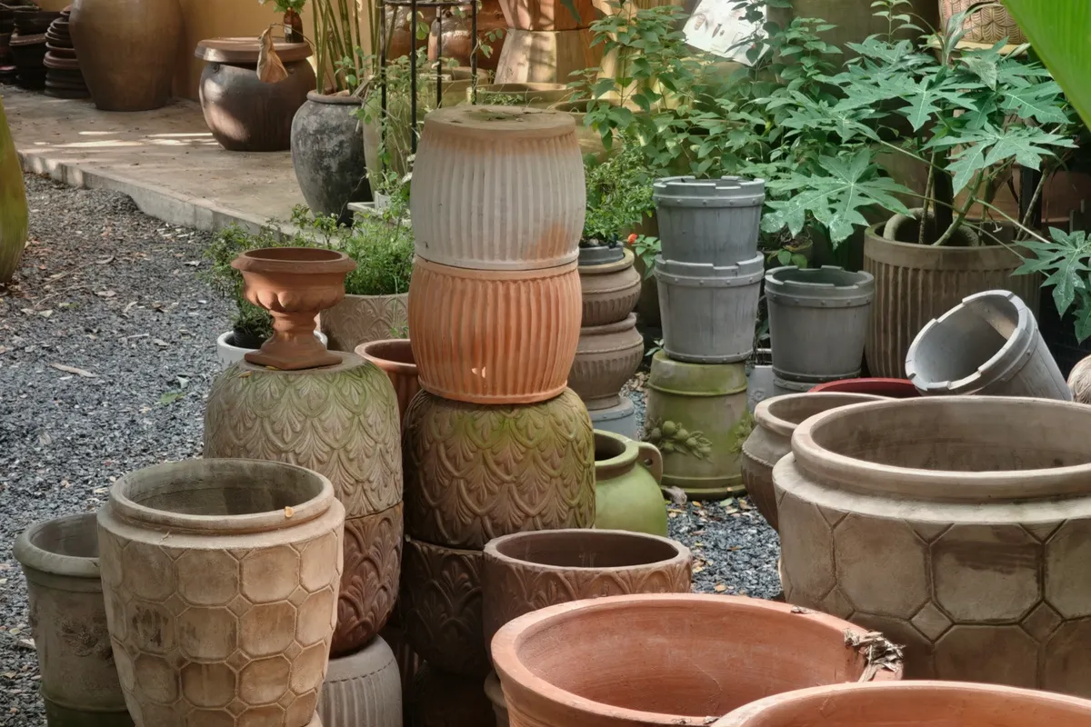 Pots en terre cuite de tailles variées disposés dans un jardin